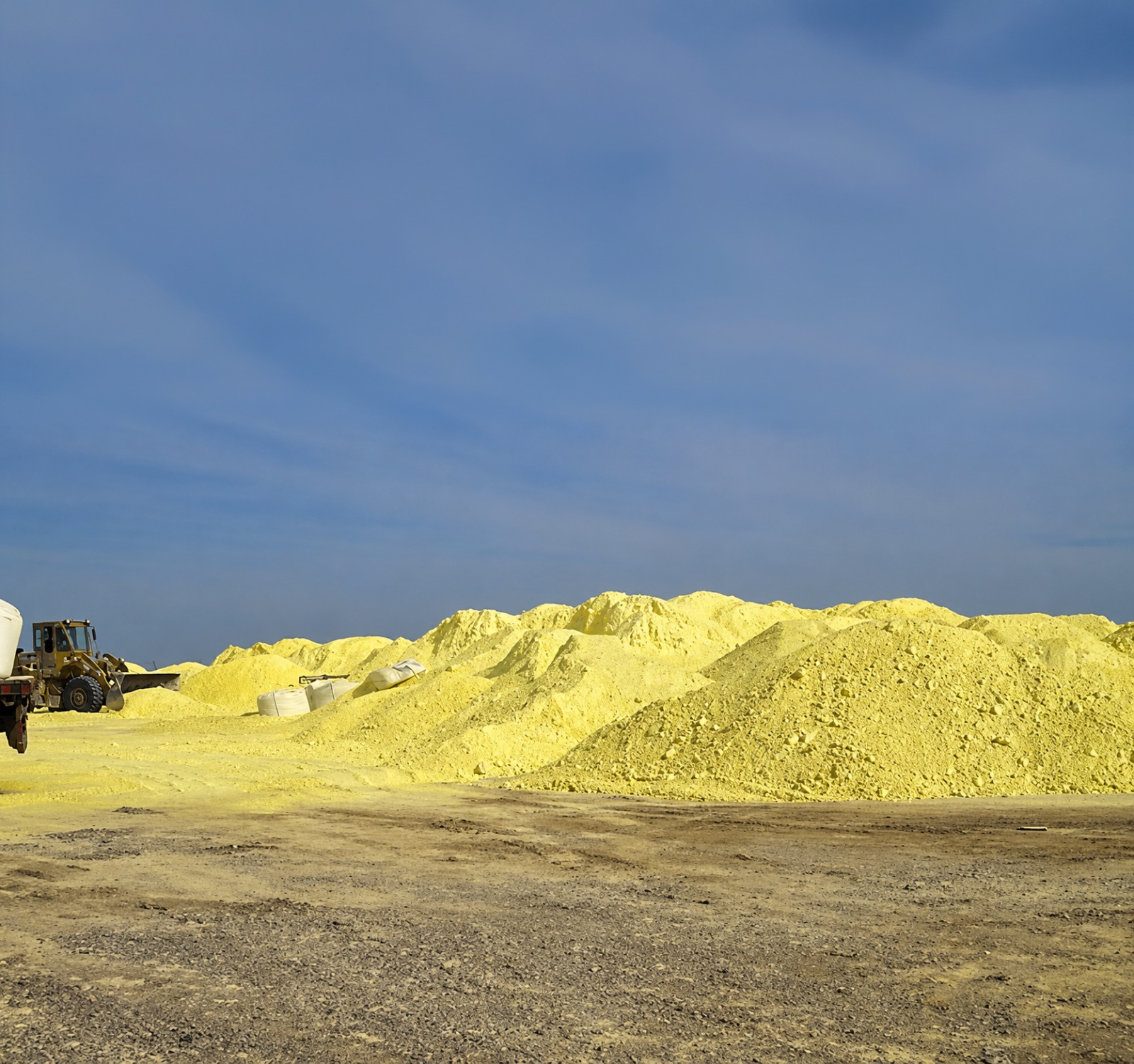 Refined sulfur stockpiles at an industrial production field.